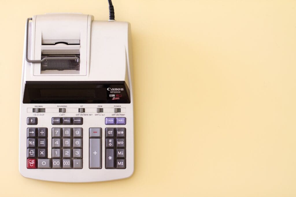 Old calculator/adding machine against yellow background