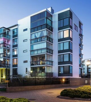 White multifamily apartment commercial property against blue sky