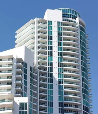 High-rise white hotel commercial building against blue sky
